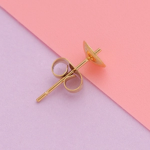 Macro shot of gold-plated stainless steel pearl earring posts and butterfly backings