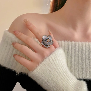 Close-up of vintage flower ring featuring a center pearl and colorful rhinestones
