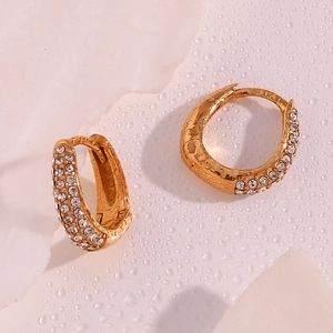 Macro detail of gold-plated hoop earrings with micro-pave white zircon stones and water drops