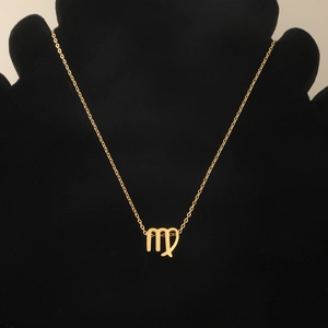 Detailed view of a gold Virgo constellation pendant necklace on a black velvet mannequin