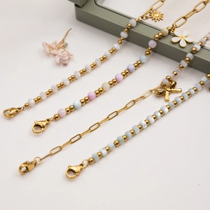 Vue détaillée de bracelets en acier doré 18 carats avec perles colorées et pendentifs fleurs