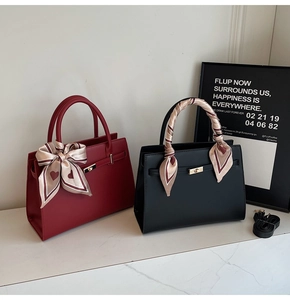 Detail of red and black leather handbags with silk scarves and gold twist-lock hardware