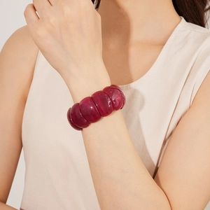 Detail of chunky burgundy acrylic geometric stretch bracelet on model's wrist