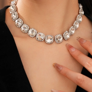 Detailed view of a silver choker necklace featuring large round zircons with tassel accents