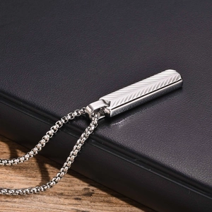 Close-up of silver stainless steel bar pendant with V-shaped texture on a box chain