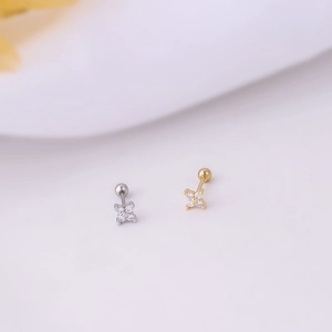 Close-up of gold and silver clover stud earrings with clear zircon and screw back details
