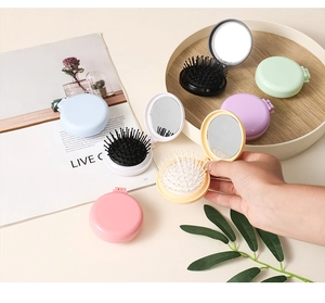 Various colors of portable folding round hairbrushes with mirrors on a desktop