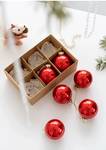 Detail of six glossy red Christmas glass balls in a minimalist kraft paper gift box