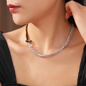 Detailed view of necklace with tiger eye beads and faceted crystals worn by a model