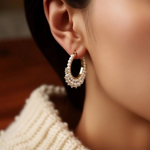 Detailed view of French vintage pearl and diamond hoop earring worn on an elegant ear
