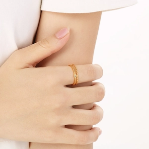 Minimalist gold stainless steel beaded ring with small diamond on female model's hand