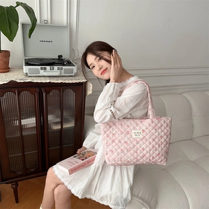 Close-up of pink floral quilted tote bag featuring a stitched label and rhombic pattern