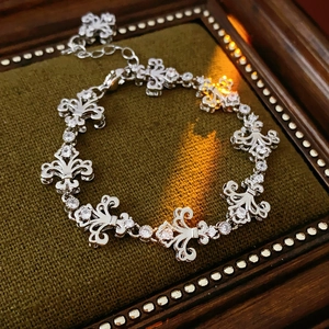 Détails du bracelet vintage fleur de lis en argent avec zircon sur plateau en velours