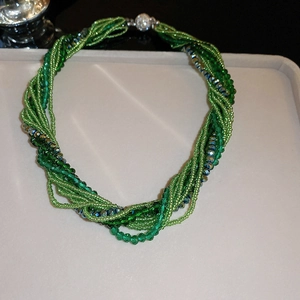 Detail of green multi-strand twisted bead necklace with crystal accents and magnetic clasp