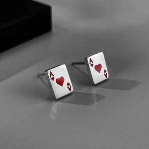 Detailed shot of silver heart ace poker earrings with red enamel playing card design
