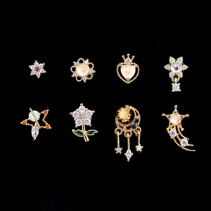 Détails de 8 clous de piercing dorés avec motifs de fleurs et d'étoiles et pierres précieuses