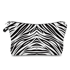 Detail of zebra print makeup bag with durable black zipper closure on white background