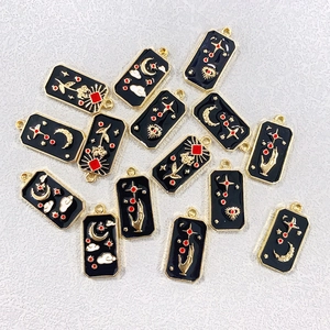 Macro detail of black and gold tarot charms featuring celestial moon and star patterns