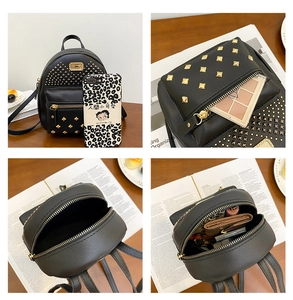 Detail of a mini black faux leather backpack with gold rivets and daily essentials