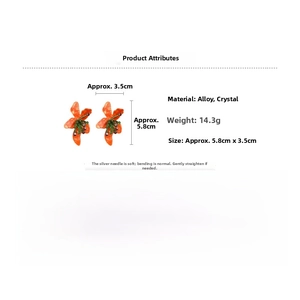 Detail showing orange flower earrings with crystal beads and silver needles measurement