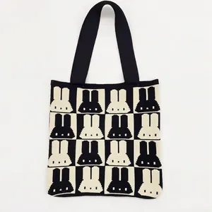 Close-up detail of knitted tote bag featuring black and white rabbit silhouette pattern