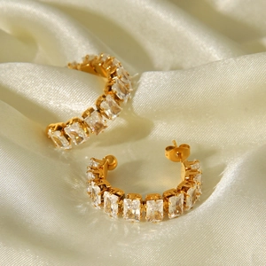 Detailed view of gold C-shaped hoop earrings with rectangular cubic zirconia inlay