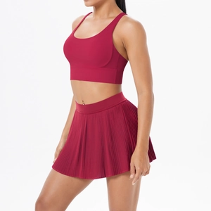 Detailed view of the dark red sports bra's racerback design and pleated athletic skirt