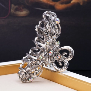 Detailed view of vintage hollow hair claw with colorful rhinestones and butterfly patterns
