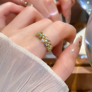 Detail of 18k gold plated vintage flower ring with green and purple zircon accents