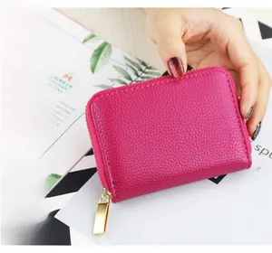 Macro view of rose red lychee grain leather wallet with golden zipper detail