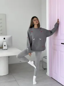 Detail of embroidered dachshund pattern on a gray knitted long-sleeved sweater for women