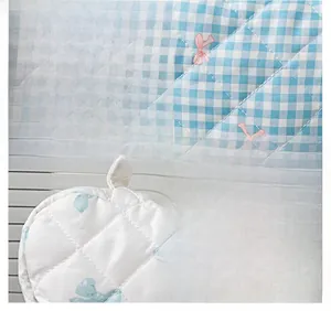 Close-up of quilted floral fabric with diamond stitching and bow patterns on cosmetic bags