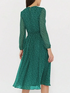 Détail de l'imprimé à pois blancs sur robe verte à manches longues avec taille nouée