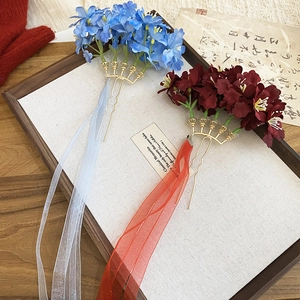 Detail of vintage fabric flower hairpins with long flowing silk ribbons and gold metal prongs
