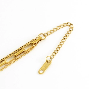 Macro shot of S.STEEL engraving on the adjustable tail chain of this gold layered necklace