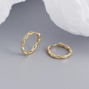 Macro detail of gold S925 silver hollow chain hoop earrings with sparkling crystal diamonds