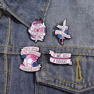 Ensemble de broches émaillées roses avec épée et rose sur fond de tissu en jean