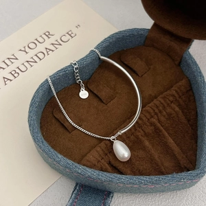 Macro detail of S925 sterling silver chain with pearl pendant in a heart jewelry box