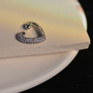 Elegant silver heart ear cuff featuring shimmering cubic zirconia pavé on white stone