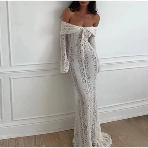 Detail of white off-shoulder lace maxi dress showing intricate floral textures and slim fit
