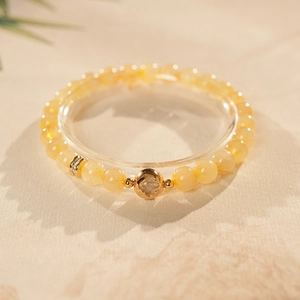 Close-up of yellow citrine gourd beads with a hollow gold-plated sphere ornament