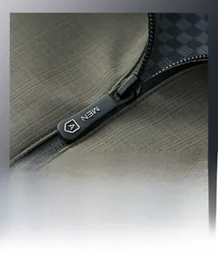 Dettaglio macro della cerniera impermeabile e del tessuto twill su giacca outdoor verde oliva