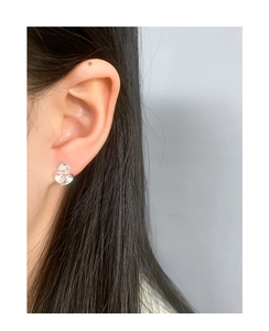 Close-up of minimalist S925 silver stud earrings with organic irregular leaf design