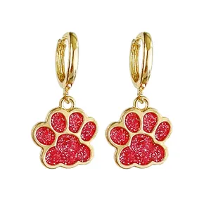 Detailansicht der Katzenpfoten-Ohrringe mit glitzernder rosa Füllung und Gold-Finish