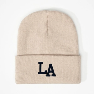 Detailed view of the 3D LA embroidery on a cream ribbed knit beanie hat