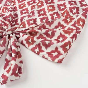 Gros plan détaillé de l'imprimé papillon rouge sur tissu blanc avec nœud latéral