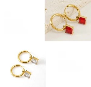Close-up of polished 18K gold earrings with square red and clear zircon stones