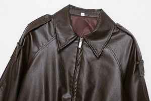 Detailed close-up of dark brown faux leather bomber jacket collar, epaulet and silver zipper