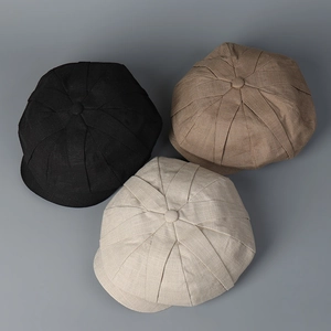 Hochwertiges Detail von drei Leinen-Schirmmützen in Schwarz, Braun und Beige Farben