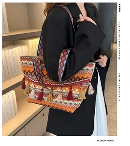 Close-up of bohemian woven tote bag with colorful tassels and geometric wide strap